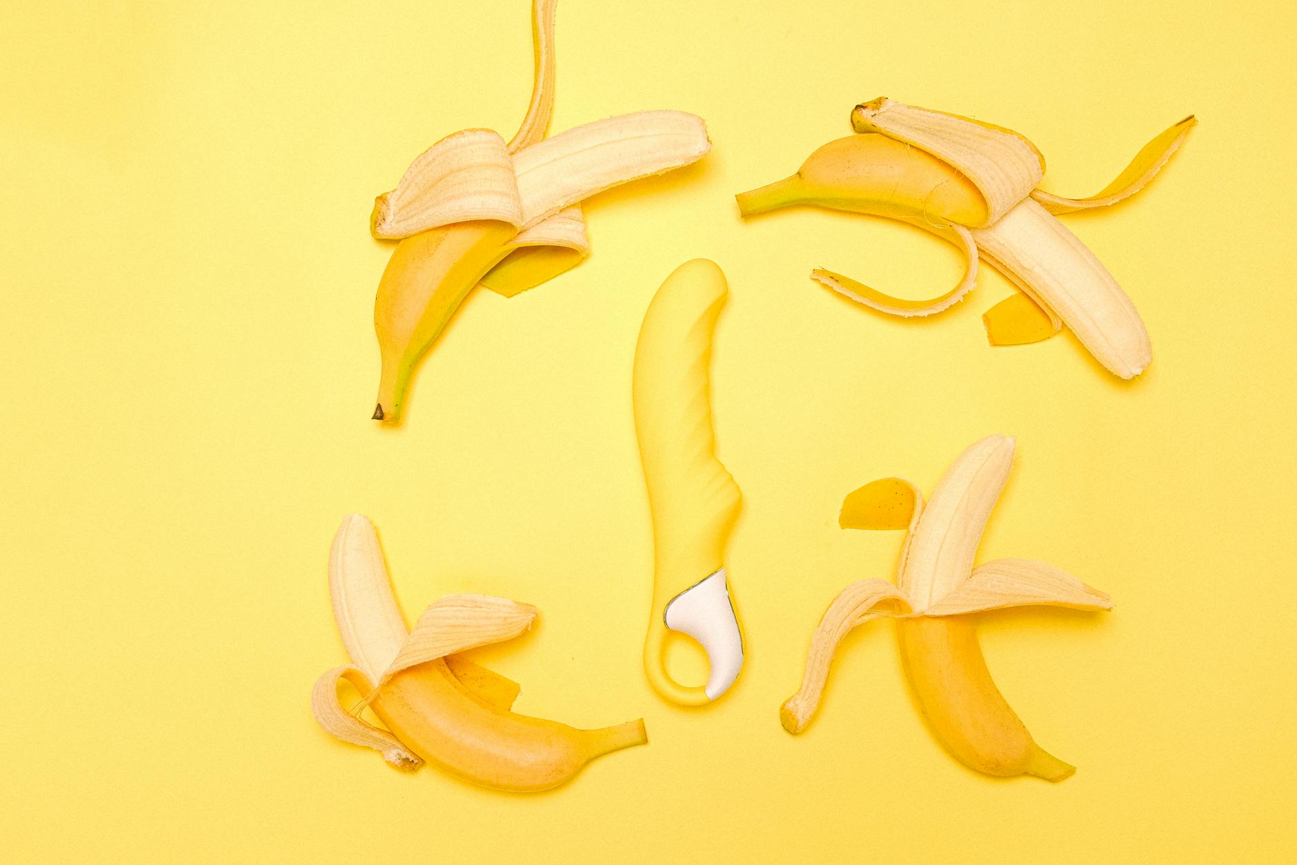 Soft yellow lemon vibrator on a bright yellow background, symbolizing gentle pleasure tools for post-surgery recovery
