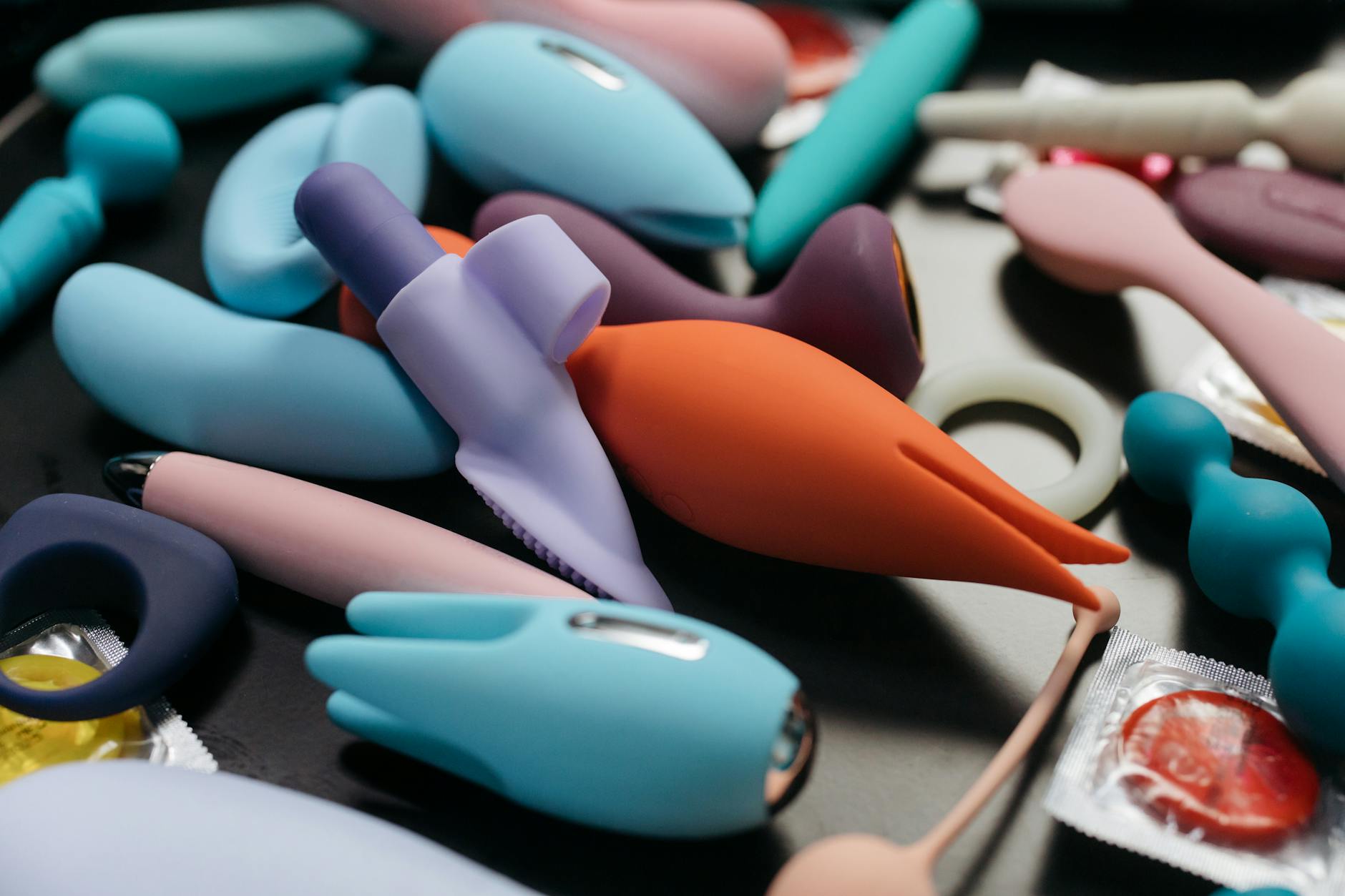 An array of colorful vibrators and adult toys displayed together.