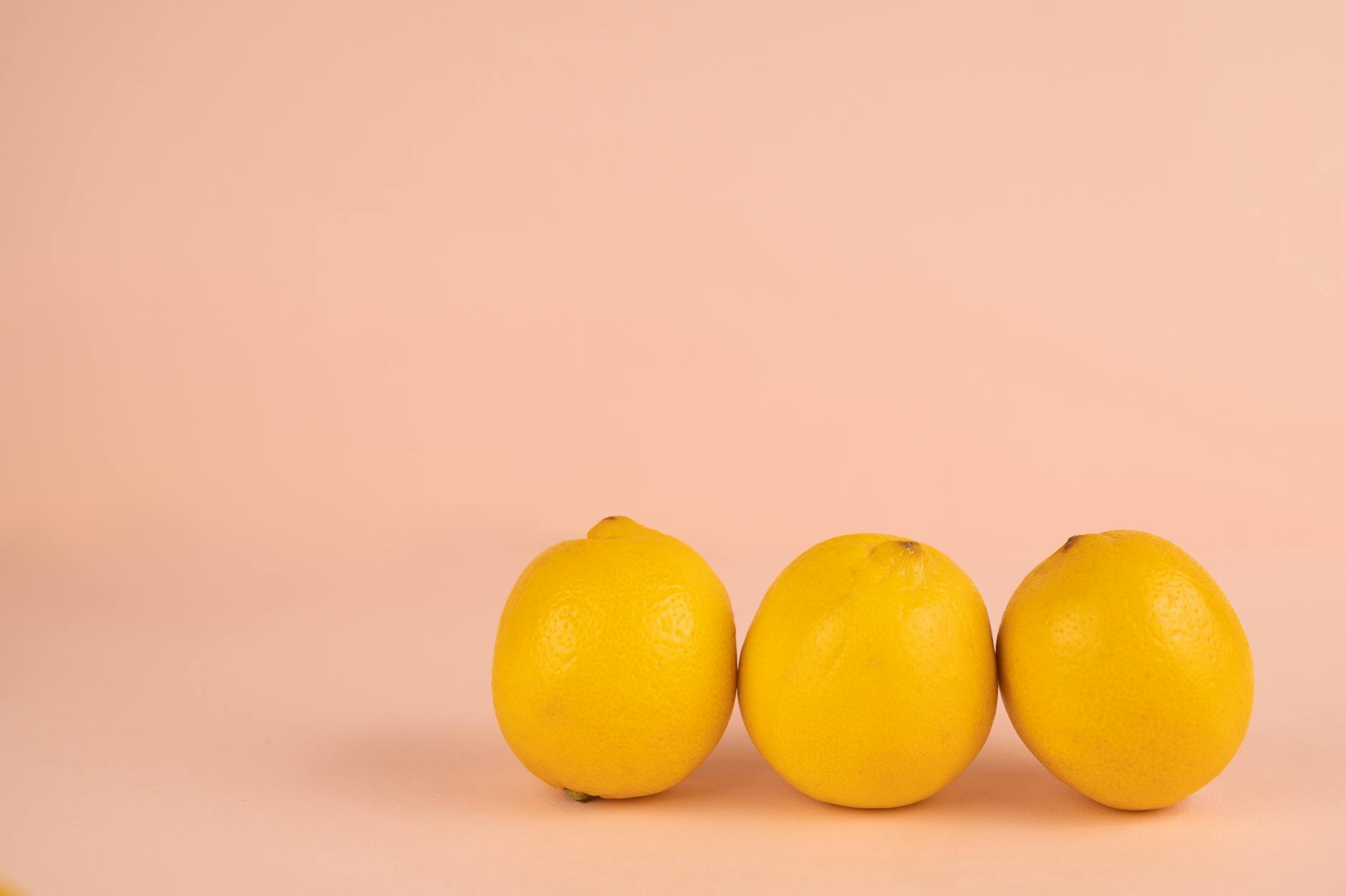 Row of bright ripe lemons with pleasant aroma on a pastel background
